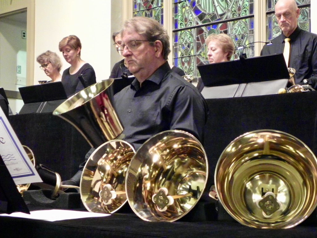 A man sitting in front of brass instruments.